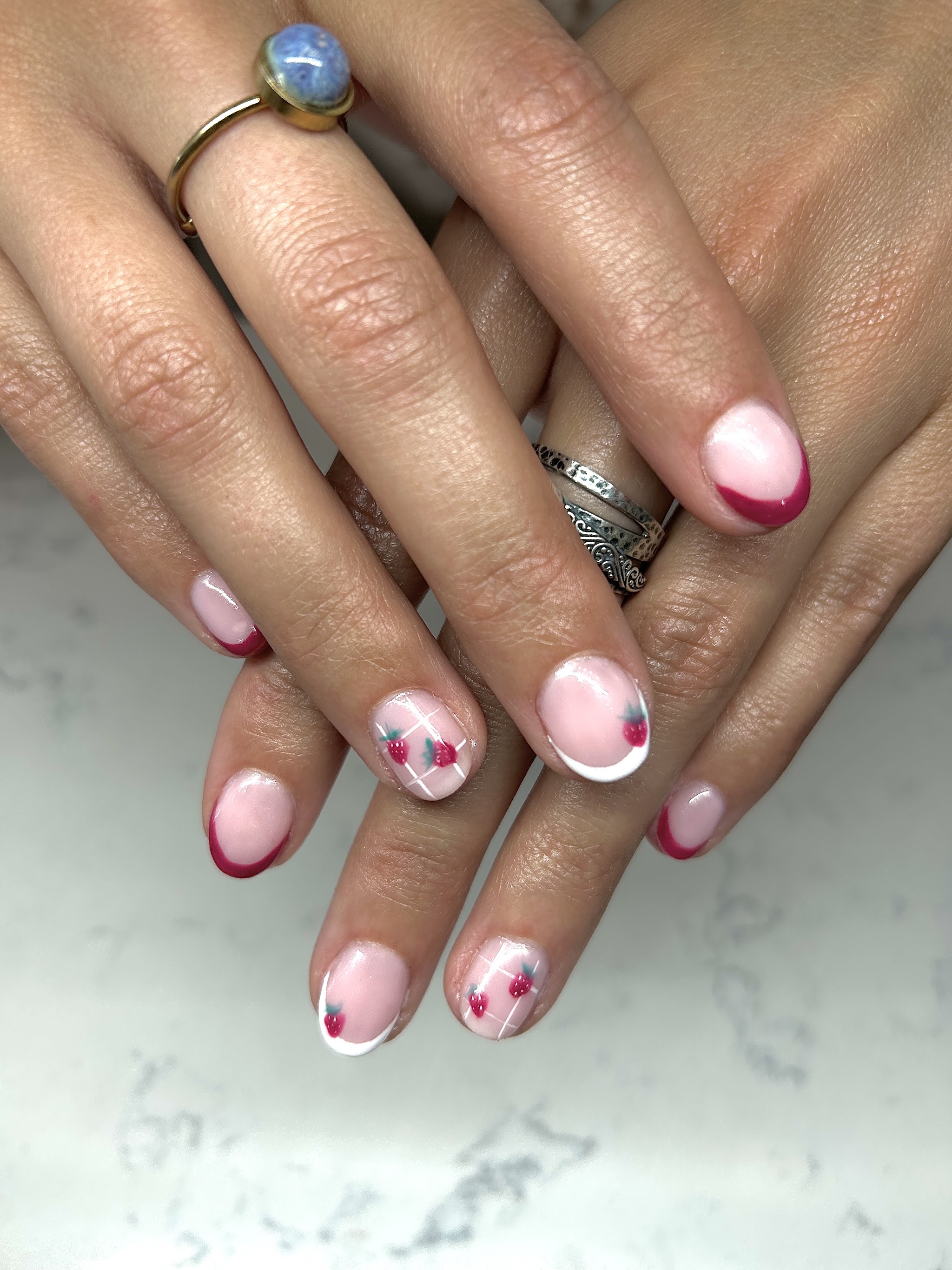 Soft pink nails with small hearts and a berry accent